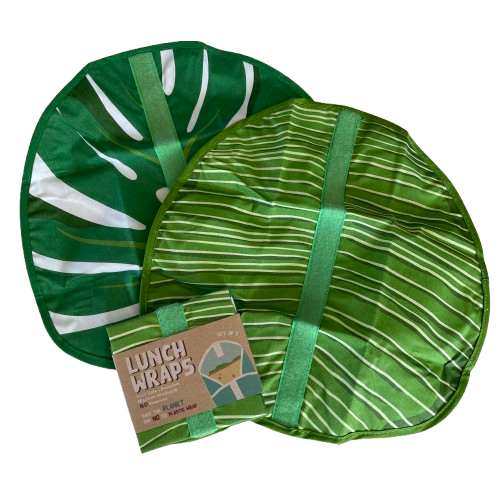 Pair of green leaf print eco friendly lunch wraps unfolded with a set folded up next to them.