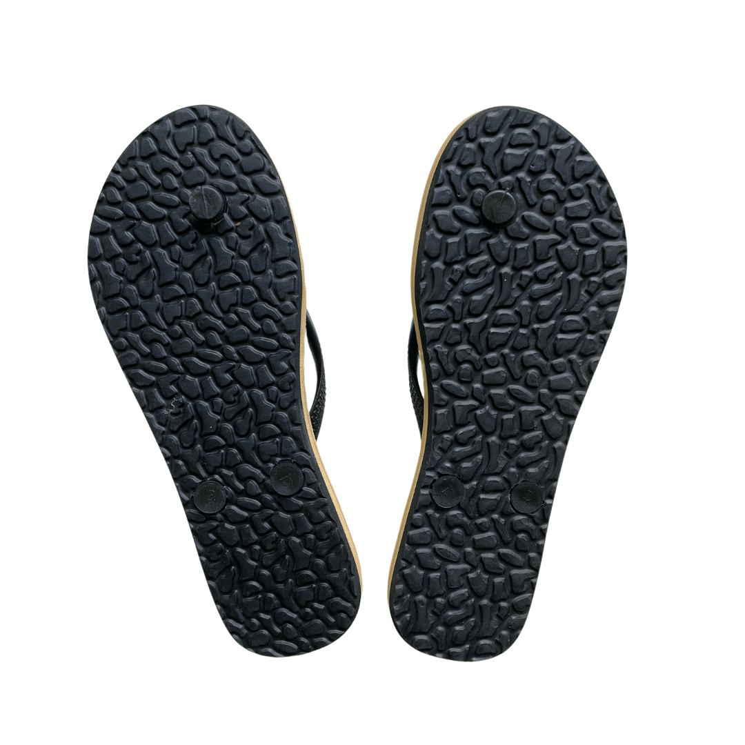 Underside of a pair of slim fit jandals showing the black grip soles. 