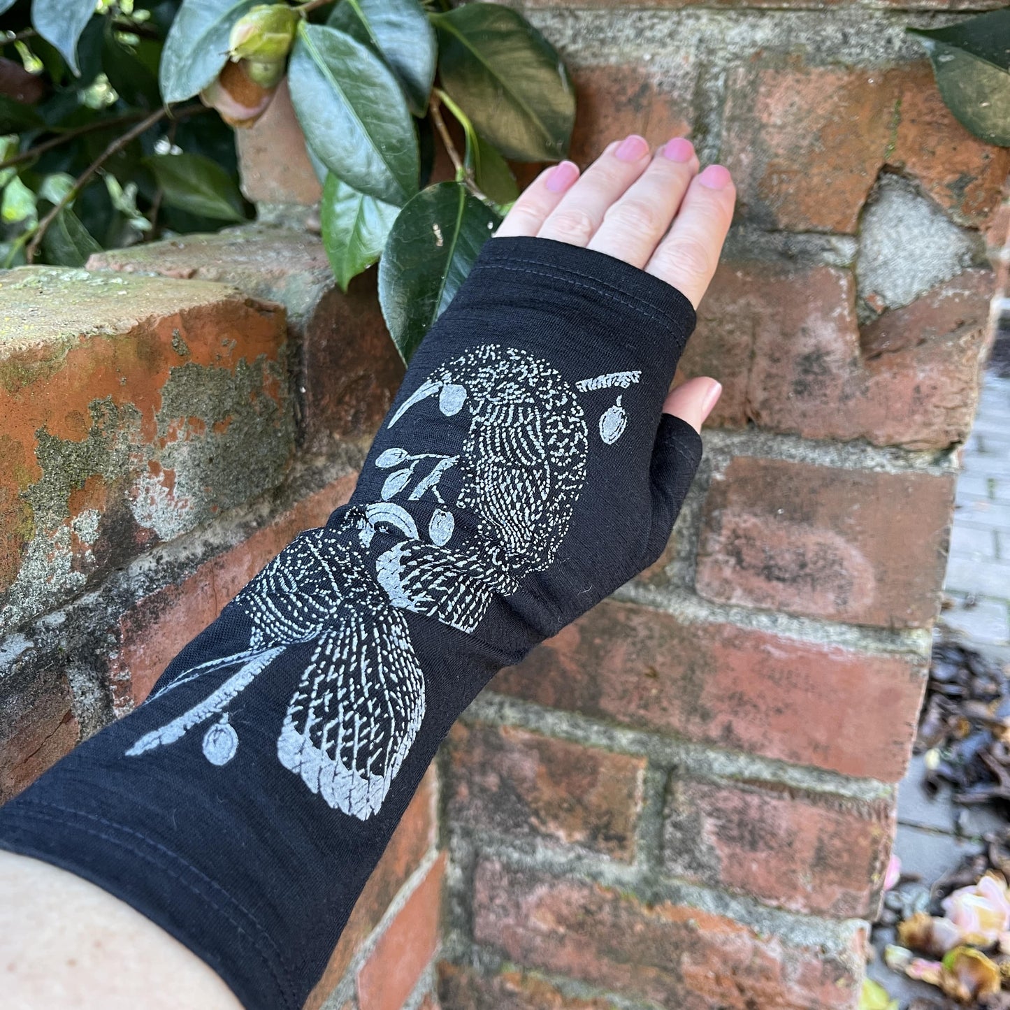 Fingerless merino gloves in black with grey Huia bird print.