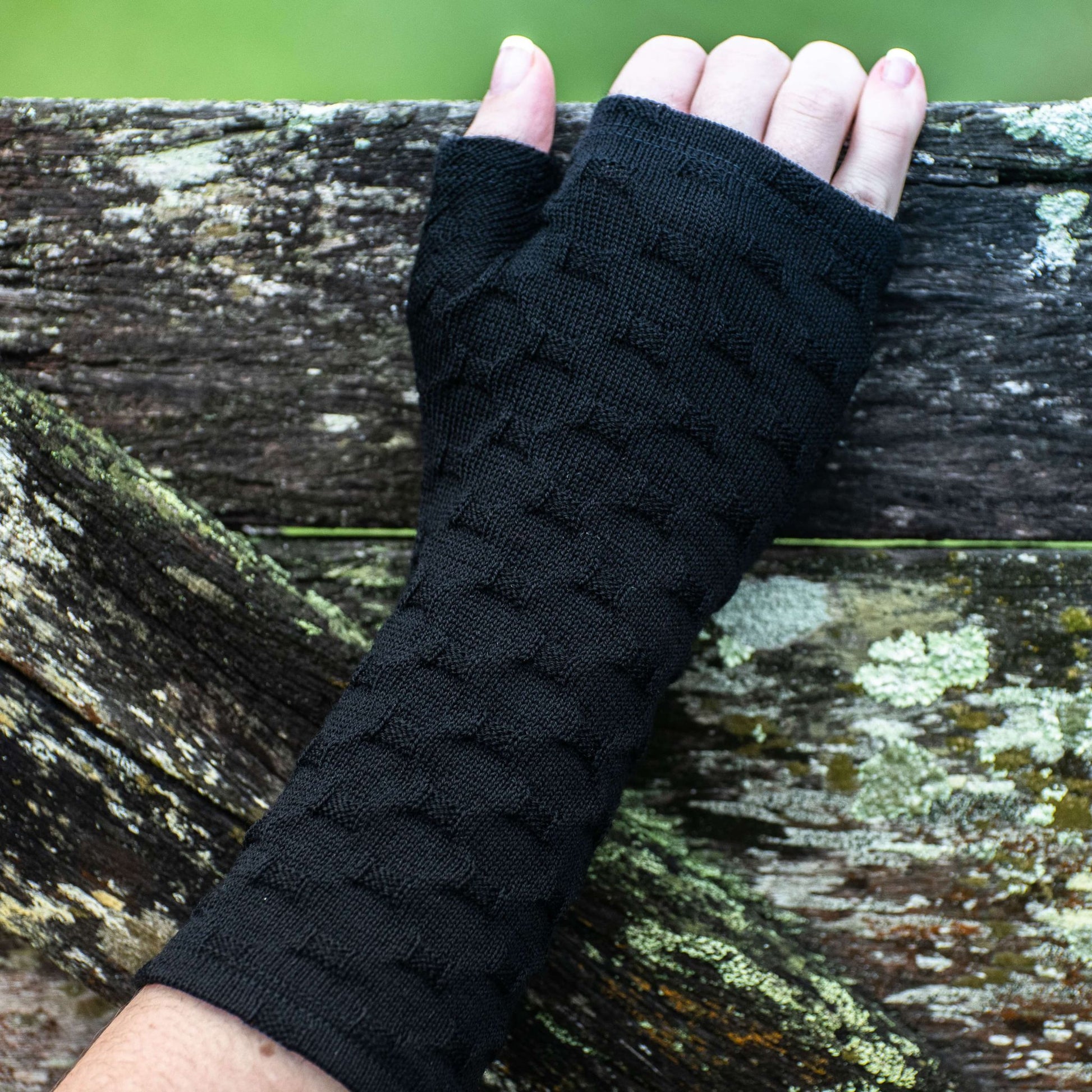 Fingerless merino gloves in textured black knit.