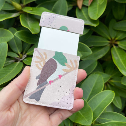 Small open pocket mirror with a Kereru bird painted on it.